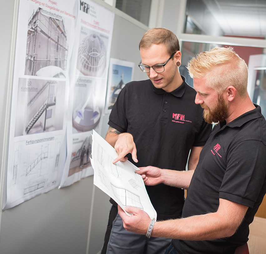 MPH Planung & Konstruktion zwei Mitarbeiter kontrollieren einen Plan