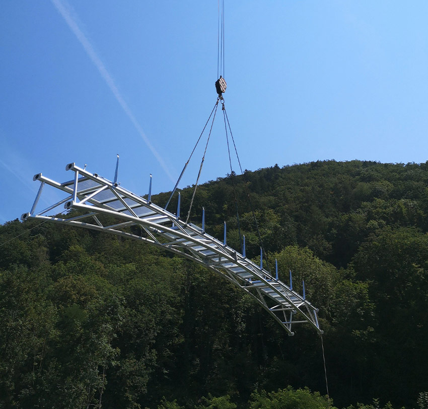 Ein Brückenelement wird mit einem Kran durch die Luft transportiert.