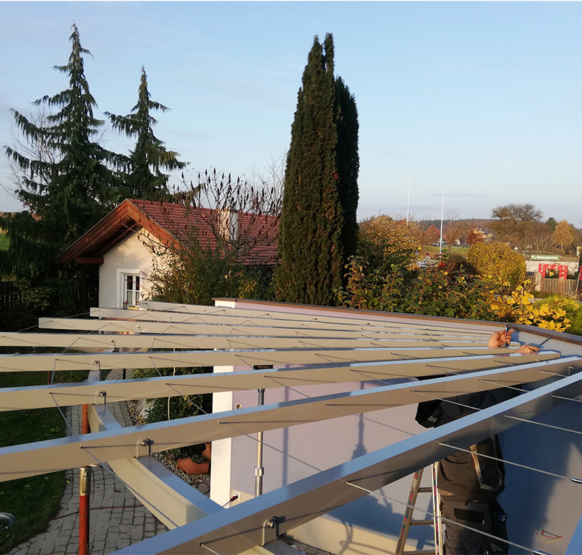Die Metallkonstruktion einer Pergola wird von einem Mitarbeiter von MPH montiert.